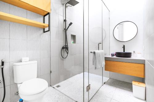 a bathroom with a shower and a toilet and a sink at Feels Like Home Villa in Keramas
