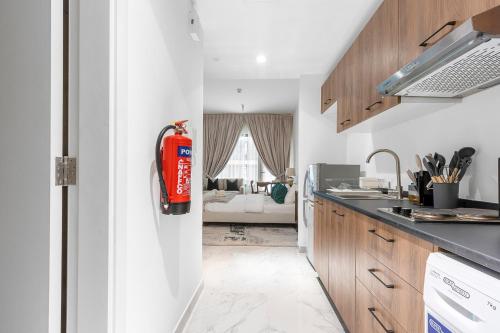 Al QurayyahにあるClassy Studio in Masdar Cityの赤い消火器付きキッチン