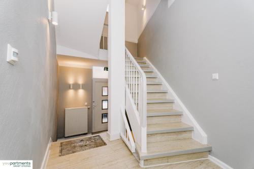 a staircase in a home with white walls and wooden floors at YOUPARTMENTS - zentrale Micro Apartments in Kaiserslautern
