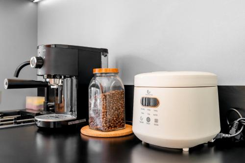 a coffee maker on a counter with a jar of coffee beans at Feels Like Home Villa in Keramas