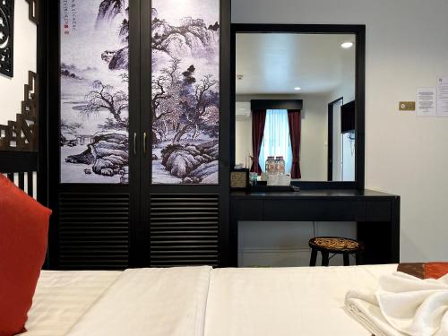 a bedroom with a mirror and a bed and a desk at Sunray Beach Hotel Patong in Patong Beach