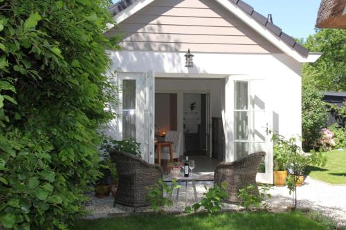 a white house with chairs in the yard at Casa Fiore in Bergen
