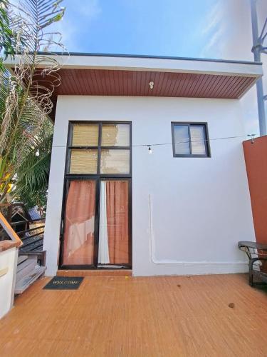 a white house with a door and windows at The Bistro House - Loft Unit - Vigan in Vigan