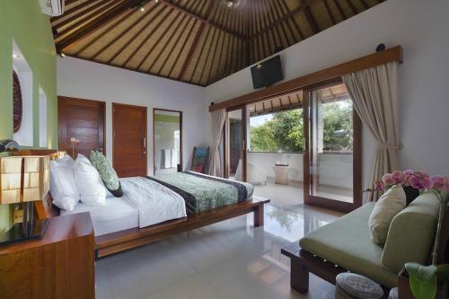Un dormitorio con una cama grande y un sofá. en ViLLA GREEN MANGGO III, en Seminyak