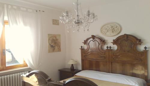 a bedroom with a wooden bed and a chandelier at Villa In Lucca in Lucca