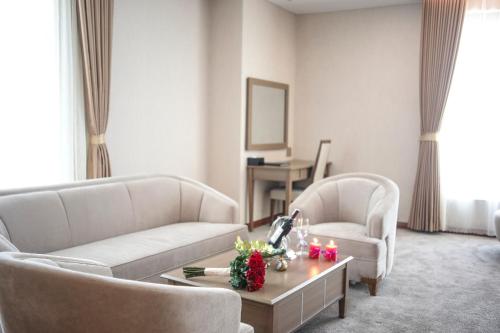 a living room with two white couches and a coffee table at Muong Thanh Luxury Ca Mau Hotel in Cà Mau