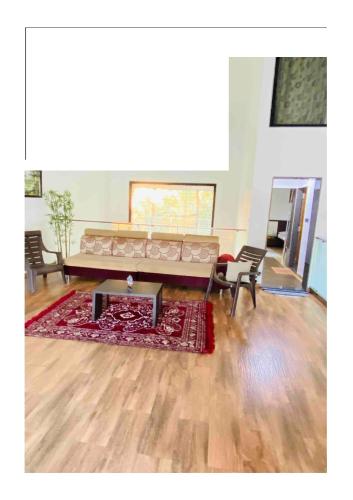 a living room with a couch and a rug at Triveni Stays Blue Gum 3BHK in Panchgani