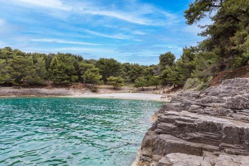 a beach next to a body of water at Skyline Apartment in Veruda