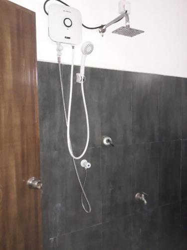 a shower with a shower head in a bathroom at Elena Garden Resort and Restaurant in Trincomalee