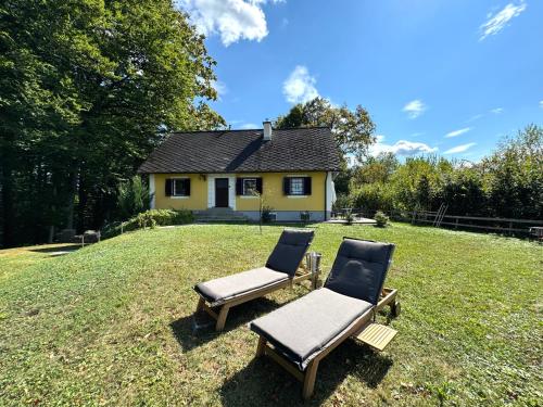 two chairs and a house on a yard at Ferienhaus Panorama - Gamlitz in Gamlitz
