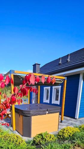 a blue and yellow house with red flowers on it at Dolina Białego Wilka - Niebieskie Domki in Zawóz