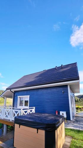 a blue house with a hot tub in front of it at Dolina Białego Wilka - Niebieskie Domki in Zawóz