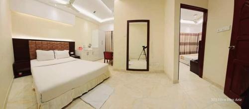 a bedroom with a large white bed and a bathroom at Resort Beach View in Cox's Bazar