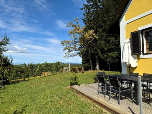 a wooden deck with a table and chairs in a yard at Ferienhaus Panorama - Gamlitz in Gamlitz