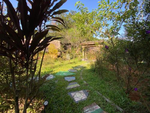 a path through a garden with rocks and trees at Ha Giang Xanh Retreat - Trekking, Tour, Motorbike Rental in Ha Giang