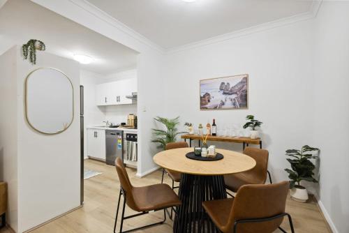 a kitchen and dining room with a table and chairs at Sleek Northbridge Getaway in Perth