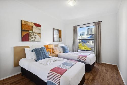 two beds in a room with a window at Perth Prime Located 2BDR 1PRK in Perth