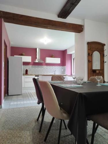 une salle à manger avec une table et une cuisine dans l'établissement La Demeure Envoutée, à Trélon