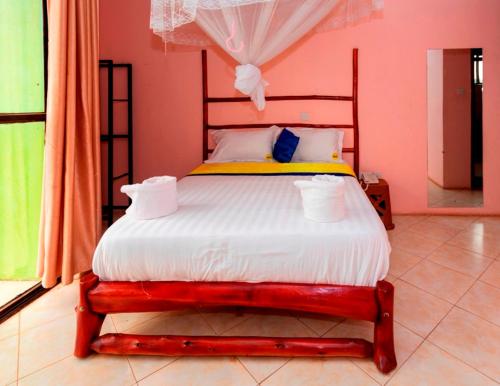 a bedroom with a bed in a pink room at Sky Beach Hotel in Wakiso