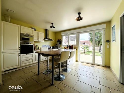 une cuisine avec une table et des chaises dans l'établissement Maison Au Puits Beriol, à Bruyères-et-Montbérault