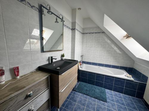 une salle de bain avec un lavabo et une baignoire dans l'établissement À 5 minutes à pieds du château, 2 belles et spacieuses chambres, SDB, WC et un garage privé à 25 minutes circuit 24h, à Le Grand-Lucé