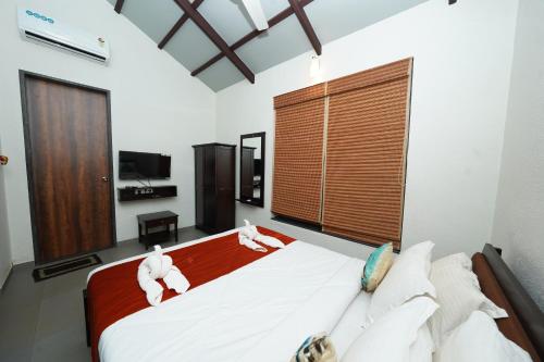 a bedroom with a large bed with towels on it at Bougain Villa Resort Park By Dream Villas in Pune