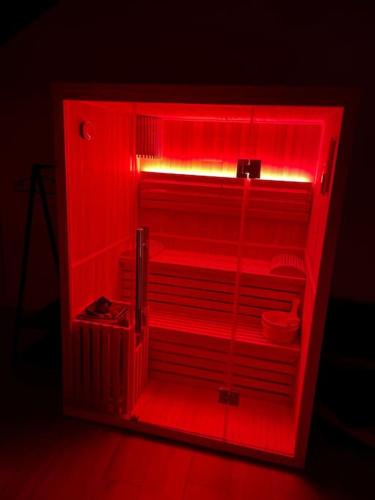 une lumière rouge dans un réfrigérateur dans l'obscurité dans l'établissement Superbe appartement jacuzzi beaune centre, à Beaune