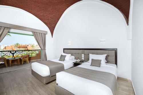 two beds in a room with a balcony at Akassia Swiss Resort in Quseir