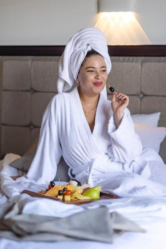 a woman sitting in a bed brushing her teeth at Akassia Swiss Resort in Quseir