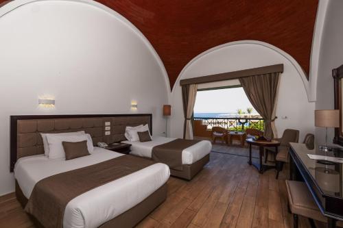 a hotel room with two beds and a balcony at Akassia Swiss Resort in Quseir