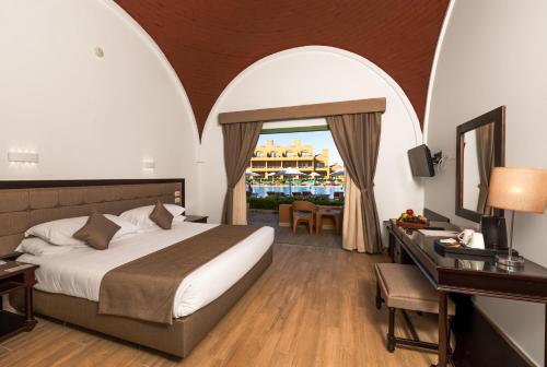 a hotel room with a bed and a desk with a desk at Akassia Swiss Resort in Quseir