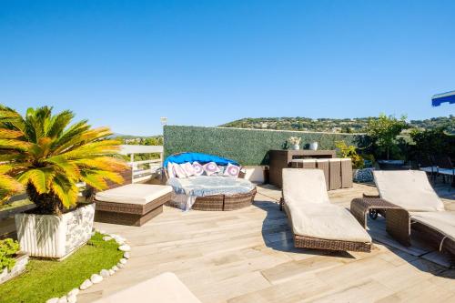 d'une terrasse avec des meubles en osier et un palmier. dans l'établissement Cannes Center Sea and Sky, à Cannes