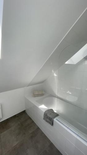 - une salle de bains blanche avec une serviette sur une étagère dans l'établissement LE PAVILLON RENNAIS, à Rennes