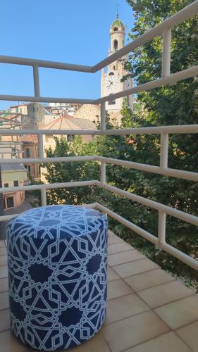 a blue trashcan sitting on a balcony with a clock tower at Casa Moret in Sanremo