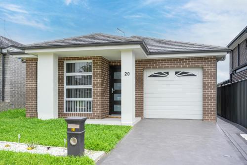 a brick house with a white garage at Denham Court 4Br with Central AC & WiFi near Coles in Leppington