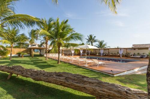 um resort com piscina e palmeiras em Pousada Brisas do Espelho em Praia do Espelho