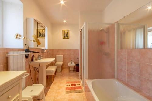 a bathroom with a tub and a toilet and a sink at Maison charmante avec jardin à Saint-Aulaire, vue sur jardin in Saint-Aulaire