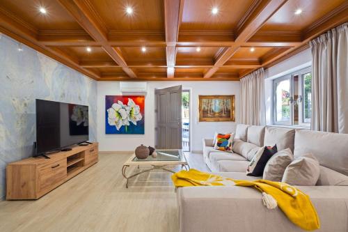 a living room with a couch and a flat screen tv at Villa Rosa Estoril Retreat by Portugal Portfolio in Estoril