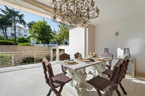 a dining room with a table and chairs and a chandelier at Villa Rosa Estoril Retreat by Portugal Portfolio in Estoril