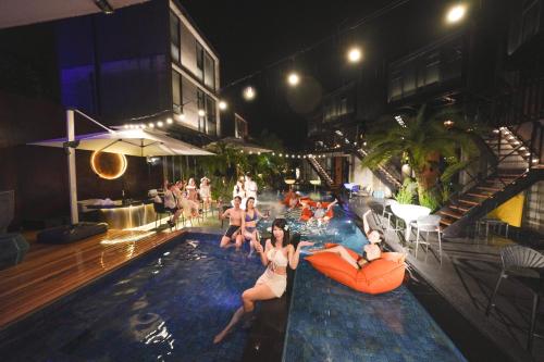a group of people sitting in a swimming pool at night at Deer Chaser Hotel in Yuchi
