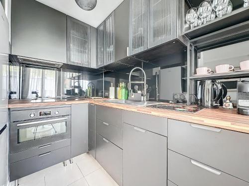 une cuisine avec des appareils en acier inoxydable et des armoires en bois dans l'établissement INTUITION - Cannes centre - 6-8 Couchages, à Cannes