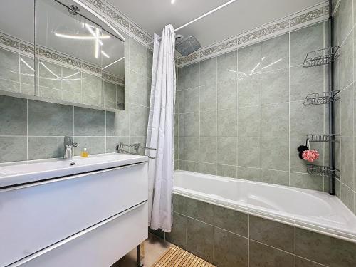 une salle de bain avec une baignoire et un lavabo dans l'établissement INTUITION - Cannes centre - 6-8 Couchages, à Cannes