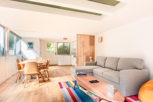 un salon avec un canapé et une table dans l'établissement Charming house with garden - Near Paris, à Courbevoie