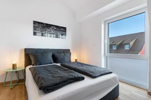 a bedroom with a bed and a large window at White House Apartments in Kappel-Grafenhausen
