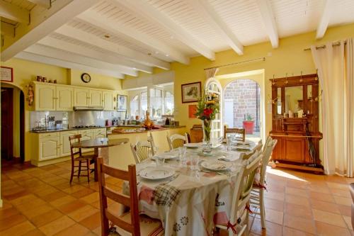 une salle à manger avec une table et une cuisine dans l'établissement Maison charmante avec jardin à Saint-Aulaire, vue sur jardin, à Saint-Aulaire