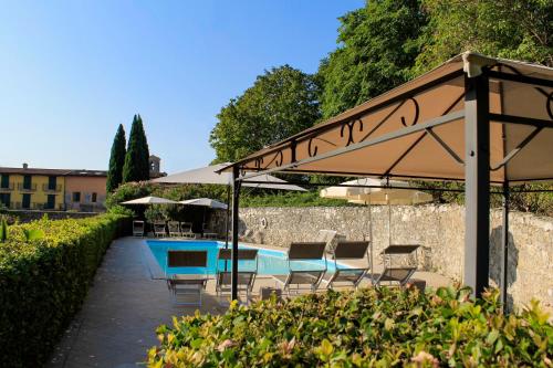 a patio with a table and chairs under an umbrella at AHG Donna Silvia Wellness Hotel in Manerba del Garda