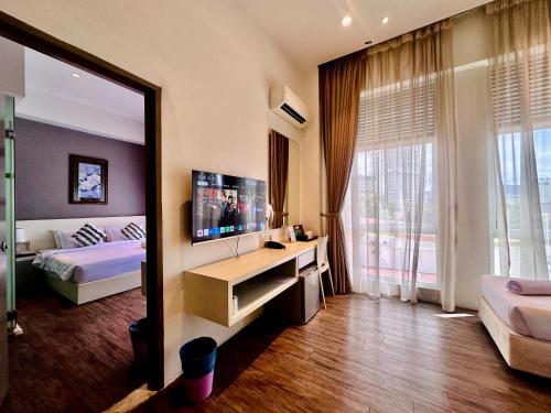 a bedroom with a bed and a television and a mirror at C Y C Heritage Hotel in George Town