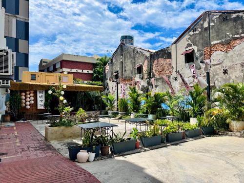 a courtyard with tables and plants in an old building at C Y C Heritage Hotel in George Town