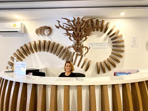 a woman sitting at a counter in front of a mirror at Sunray Beach Hotel Patong in Patong Beach