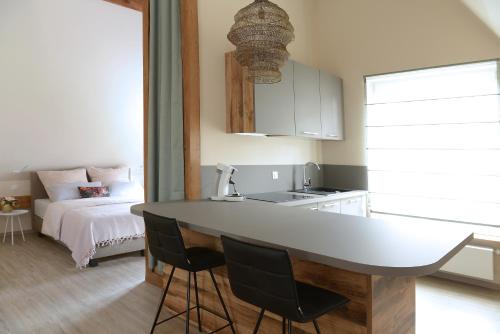 a kitchen with a table and a bed in a room at Remise 68 - Historisches Anwesen beim Maison 1775, mit Sauna, Wissembourg, Elsass in Ingolsheim
